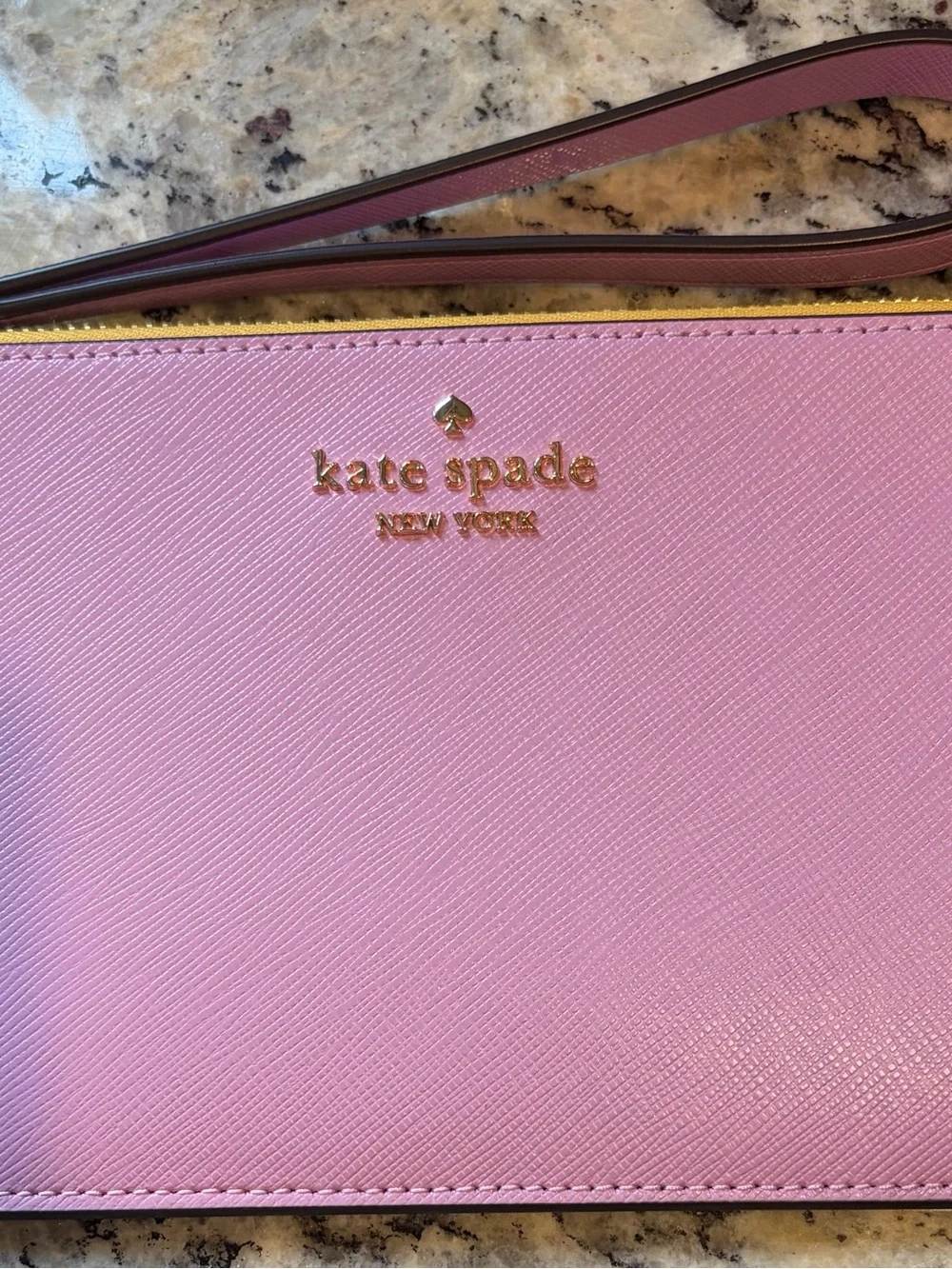 Best offer for quick sale Kate Spade Pink/Yellow Wristlet with Gold lettering.